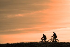 two people riding bikes in sunset for ibd